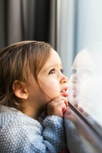 family mental health covid little girl looking out window