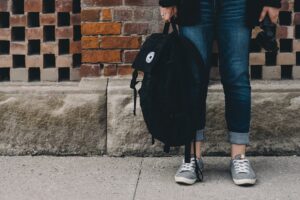 parenting young adult children young man's legs and backpack standing on street